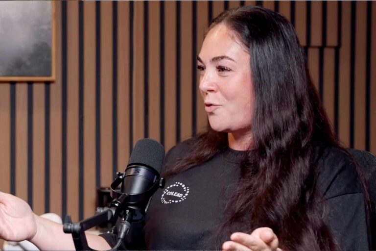 Nichole Alexander speaking into mic in interview room for podcast